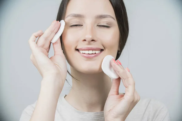 Woman using cotton pad. Healthy skin brunette woman closeup face clean healthy skin