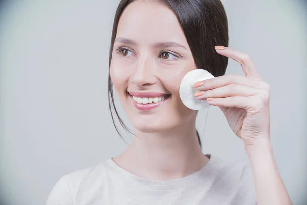 Woman using cotton pad. Healthy skin brunette woman closeup face clean healthy skin