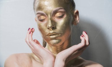 yakın portre kız makyaj fırçası tutun, altın yüz makyaj