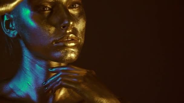 时尚模特女性金皮肤脸在明亮的火花 时尚发光的金色皮肤化妆 闪光金属光泽化妆 — 图库视频影像