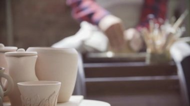 Potter 'ın elinin yakın çekimi Potter' ın tekerleğinde bir sürahi kil yontuyor.