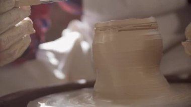 Kendi atölyesinde yeni kil öğe üzerinde çalışan iş giyim genç başarılı çömlekçi