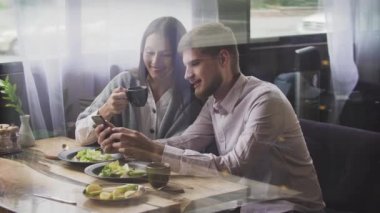 Çift restoranda seyir onun akıllı telefon