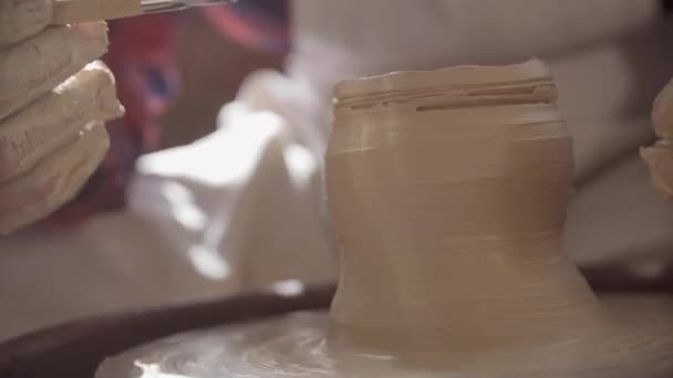 彼自身のワークショップで新しい粘土アイテムの上に働くワークウェアの若い成功した陶芸家 — ストック動画