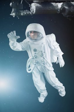 uzayda astronot elini sallayarak