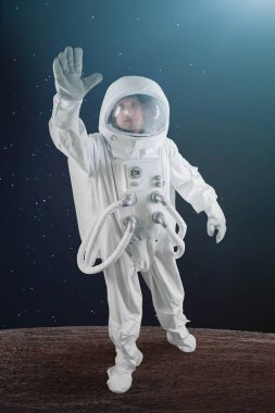 uzayda astronot elini sallayarak