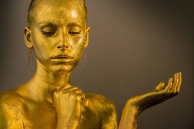 yakın portre kız makyaj fırçası tutun, altın yüz makyaj