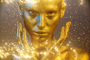 yakın portre kız makyaj fırçası tutun, altın yüz makyaj