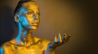 yakın portre kız makyaj fırçası tutun, altın yüz makyaj