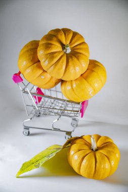 Bayram indirimleri ve sonbahar satışlarının sembolü olarak süpermarketten sepetli Cadılar Bayramı balkabakları.