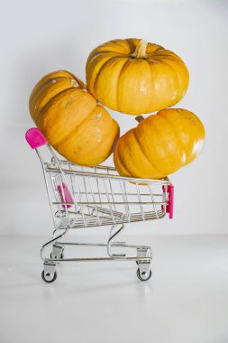 Bayram indirimleri ve sonbahar satışlarının sembolü olarak süpermarketten sepetli Cadılar Bayramı balkabakları.