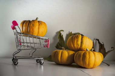 Bayram indirimleri ve sonbahar satışlarının sembolü olarak süpermarketten sepetli Cadılar Bayramı balkabakları.