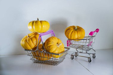 Bayram indirimleri ve sonbahar satışlarının sembolü olarak süpermarketten sepetli Cadılar Bayramı balkabakları.