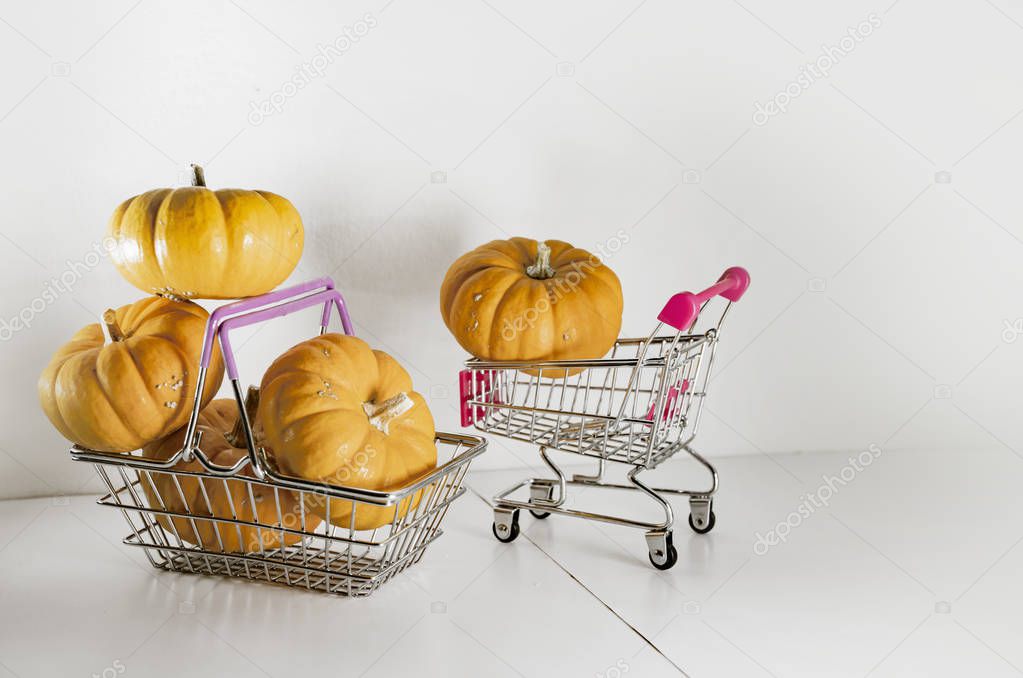 Halloween pumpkins in basket from the supermarket as a symbol of holiday discounts and autumn sales