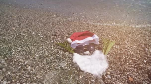 热带海滩上的圣诞老人帽和太阳镜 圣诞假期的概念 — 图库视频影像