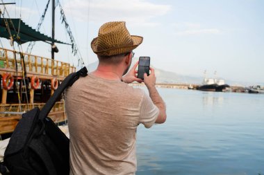 Turist tatilde manzaranın fotoğrafını çeker.