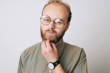 Sakalını dokunmaktan ve kameraya bakarak adam Genç sakallı