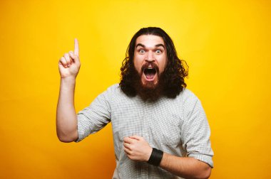 Sakallı adam sarı arka plan üzerinde yukarıyı hayran