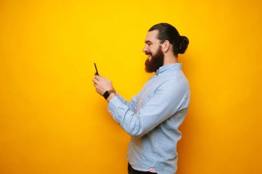 Casual kullanarak sakallı yakışıklı telefon sarı arka plan üzerinde