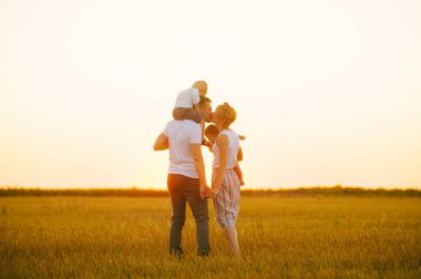 Gün batımı öpüşme, aile anne baba ve çocuklar genç Aile