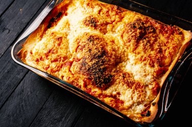 Koyu ahşap masa üzerinde taze pişmiş lazanya