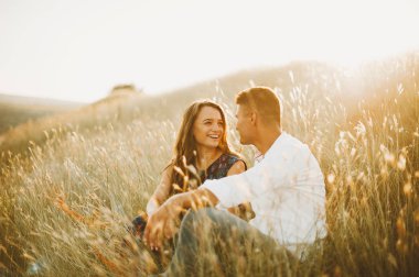 Mutlu aşk çift doğada açık gün batımında, kız, nişan gülüyor eğleniyor 