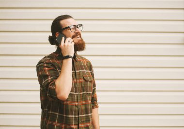 Yakışıklı genç sakallı adam cep telefonu üzerinde konuşurken