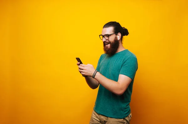 Young Cheerful Bearded Man Using Modern Technology Phone Wireless Earphones — Stock Photo, Image