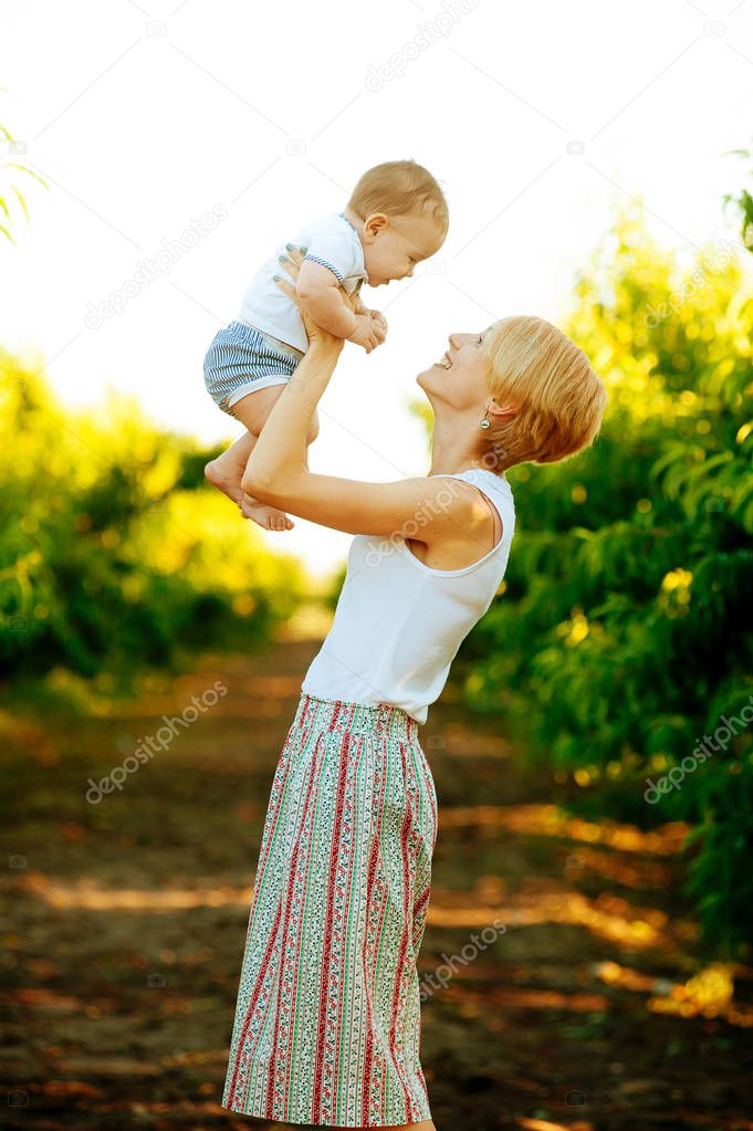 Happy young mother playing with her kid outdoor 