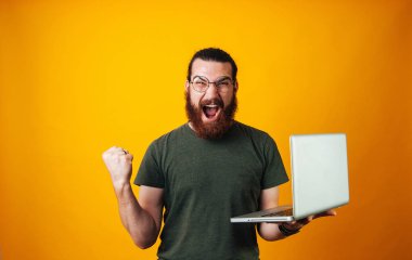 Kazanan gözlük takan ve onun defter tutan ve bir kazanan jest yapma kameraya bakarak adam sakallı.