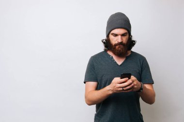 G.Pasquali genç adam onun telefon smartphone vasıl bakan sakallı. Antisosyal kavramı. Teknoloji kavramı.