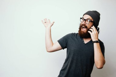 Fotoğraf yakışıklı heyecanlı adam sürpriz yüzündeki ifade ve beyaz arka plan üzerinde telefonla konuşurken el hareketi