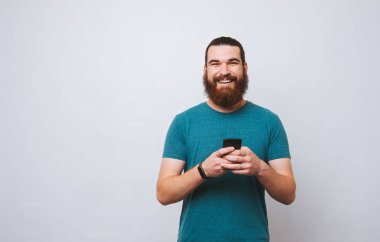 Sakallı adam kendini onun cep telefonu tutan kameraya bakıyor kabul gülümseyen.