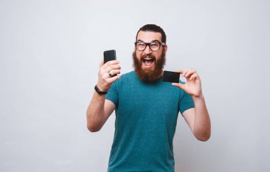 Sakallı adam online tutarak onun smartphone ve kredi kartı alışveriş heyecanlı.