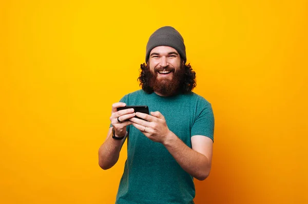 Cheerful Man Looking Camera Playing Phone Yellow Backgorund — Stock Photo, Image