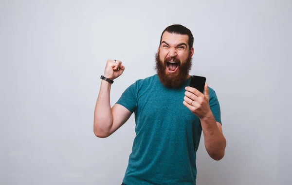 Bearded Man Winner Eith Smartphone Hand Screaming White Background — Stock Photo, Image
