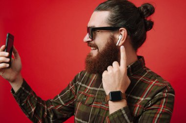 Telefon istimal ve airpods müzik dinlemek mutlu sakallı hippi adam portresi