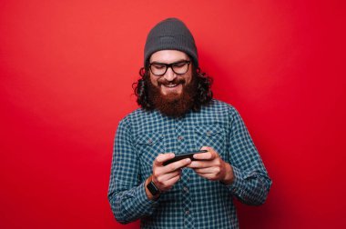 Smartphone cep telefonu ile rahat oyun oyunda sakallı neşeli adam portresi