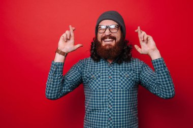  Kırmızı bir arka plan üzerinde kenetlenmiş parmaklar ile sakallı adam portresi