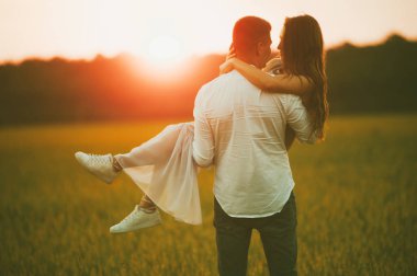 Erkek ve kadın üzerinde yeşil bir alana batımında aşık.