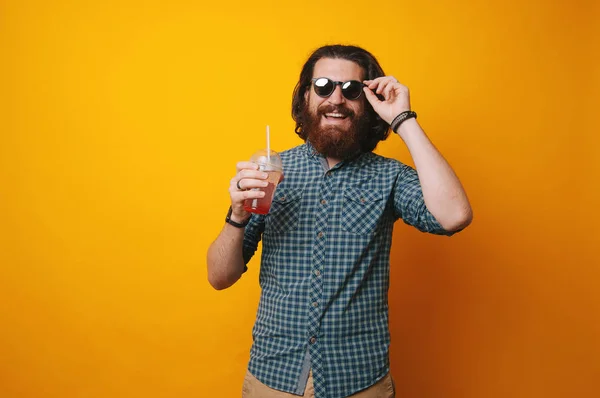 Bärtiger Mann Mit Sonnenbrille Und Einem Glas Saft Auf Gelbem — Stockfoto