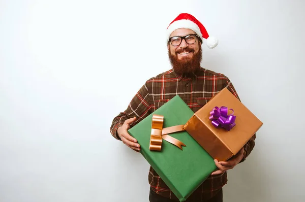 クリスマスのギフト用の箱を保持しているサンタ クロースの帽子と幸せなひげを生やした男 ホワイト バック グラウンド上の新年 — ストック写真