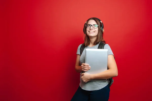 Щаслива Молода Жінка Студент Слухає Музику Тримає Ноутбук Червоному Тлі — стокове фото