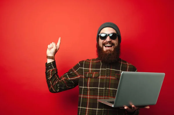 Hombre Feliz Con Barba Sosteniendo Ordenador Portátil Apuntando Hacia Arriba — Foto de Stock