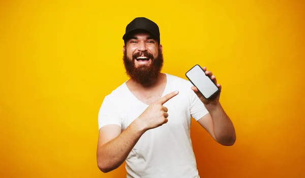 Hombre Hipster Barbudo Feliz Apuntando Teléfono Inteligente Sobre Fondo Amarillo — Foto de Stock