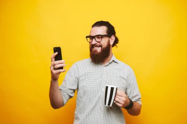 Sakallı adam bir mesaj ve içecek kahve okuma