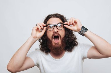 Beyaz arka plan üzerine gözlük ile hayrete sakallı adam portresi