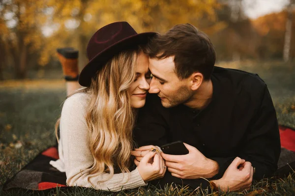 幸せな素敵な若いカップルは公園の芝生の上を敷設します 秋の時間のロマンチックな美しいカップル — ストック写真
