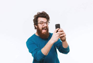 Smartphone vasıl seyir ve çığlık neşeli yakışıklı sakallı hippi adam 