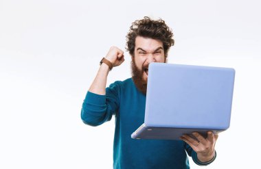 Beyaz arka plan üzerinde duran ve başarı kutluyor ve dizüstü tutan sakallı heyecanlı adam